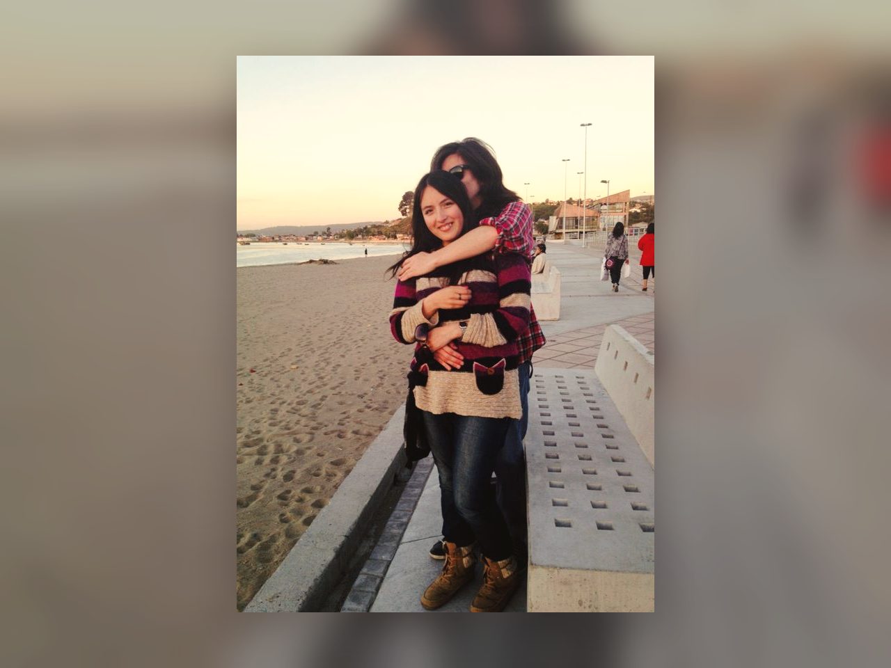 Pareja abrazada en la playa al atardecer durante sus primeros años juntos.