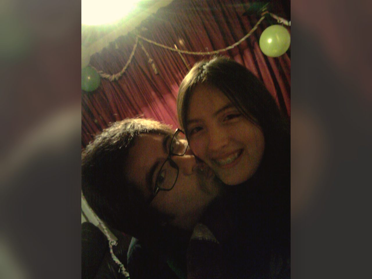 Selfie antigua de la pareja sonriendo en una celebración.