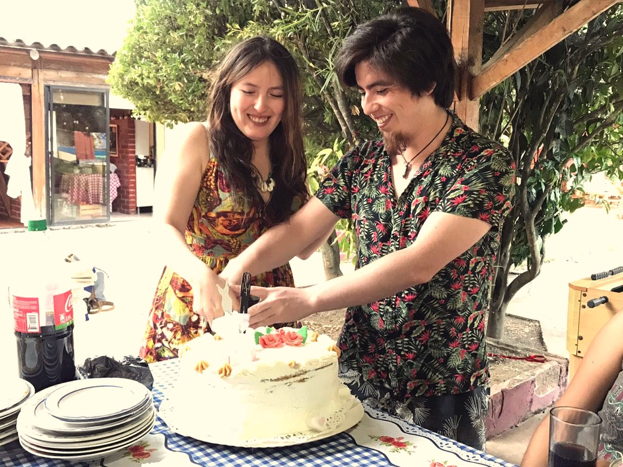 Pareja cortando una torta en una celebración familiar.